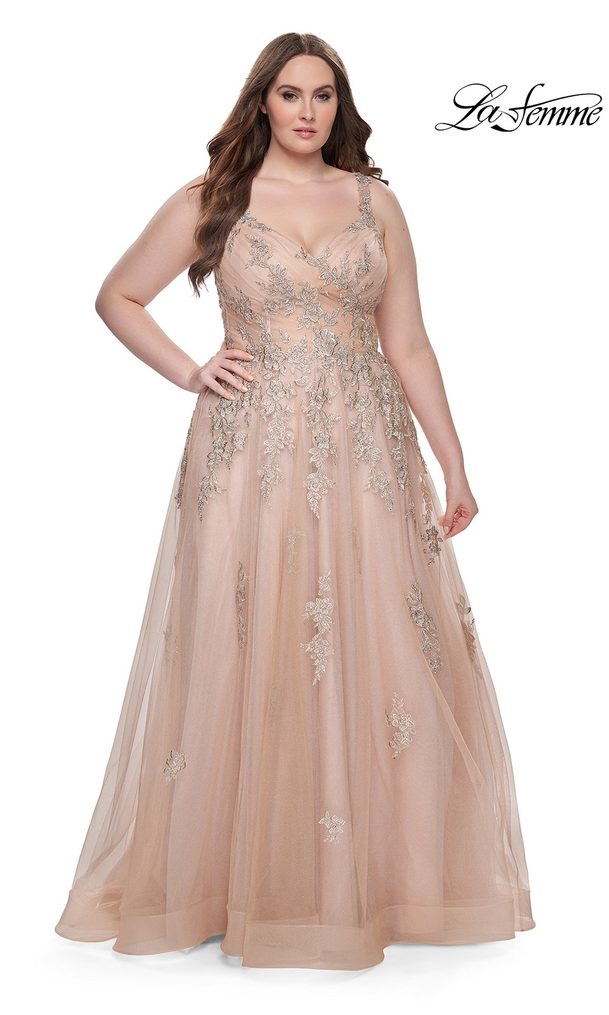A woman poses with one hand on her hip in the La Femme Long Prom Dress 31383, a floor-length blush lace gown with silver floral embroidery and a tulle overlay, against a white background. The La Femme logo appears in the top right corner.